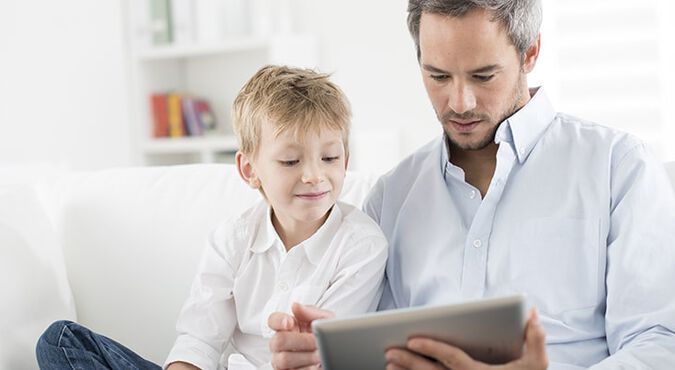Padre e hijo juegan en el iPad